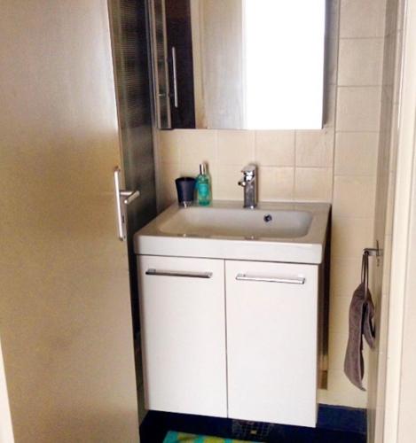 une salle de bain avec un lavabo blanc et un miroir dans l'établissement Biarritz, hyper centre, 50M plages, wifi, à Biarritz