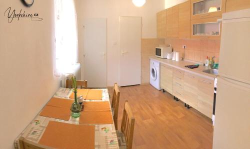 uma cozinha com uma mesa com cadeiras e um frigorífico em Apartment Yorkshire em Bujanov