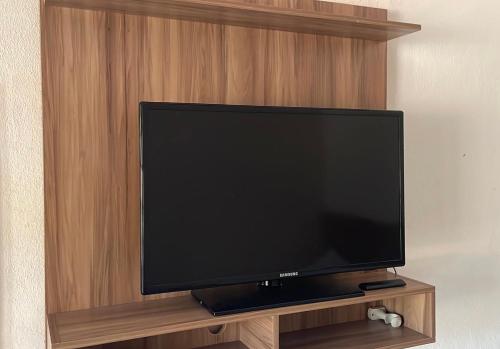 a flat screen tv sitting on a wooden entertainment center at Pousada Plantar e Cuidar in Santa Cruz do Escalvado