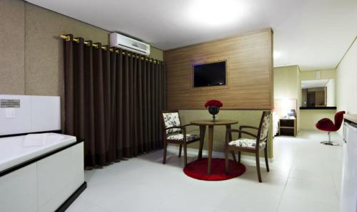 Zimmer mit einem Tisch und Stühlen sowie einer Küche in der Unterkunft ROMA'S HOTEL in Umuarama