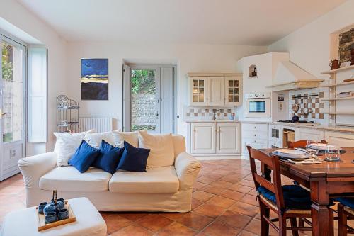 uma sala de estar com um sofá branco e uma mesa em La Suite del Castello em Belgirate