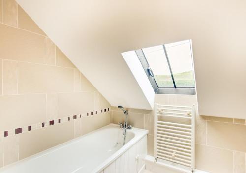 a bathroom with a bath tub and a window at Crud y Werin in Llandderfel
