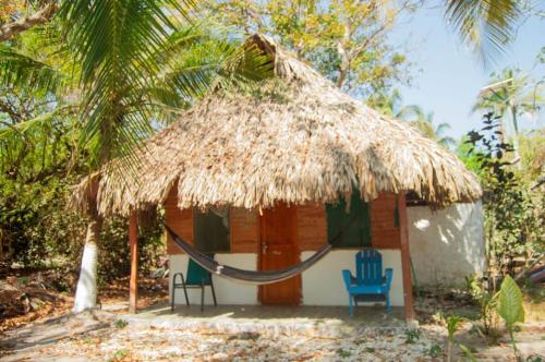 uma pequena cabana com duas cadeiras e um telhado de palha em Eco Hotel Campo Verde em Isla Grande