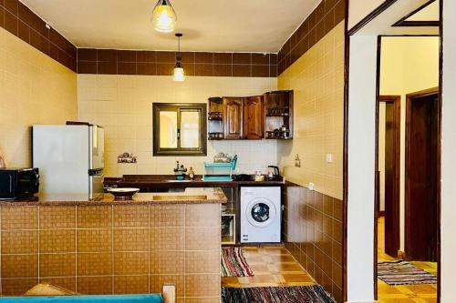 cocina con nevera y lavadora en Sea Breeze Beach House, en Dahab