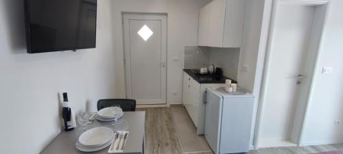 a small kitchen with a table and a refrigerator at Rooms Lucky in Makarska