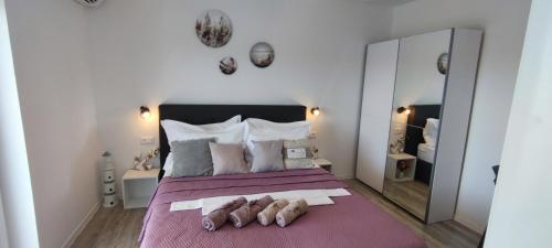 een slaapkamer met een groot bed en een paarse deken bij Rooms Lucky in Makarska