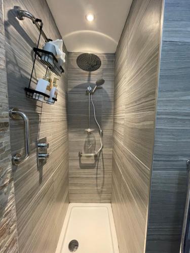 een badkamer met een douche met een douchekop bij Saorsa House Culross in Fife