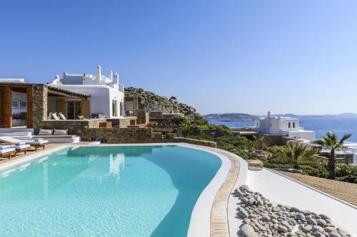 a villa with a swimming pool with a view of the ocean at Villa Yasmina in Tourlos
