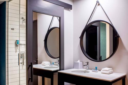 uma casa de banho com dois lavatórios e dois espelhos em Aloft Philadelphia Downtown em Filadélfia
