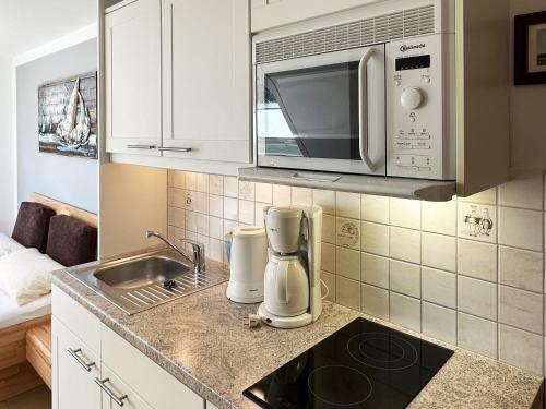 una cucina con lavandino e forno a microonde di Haus *Üüs Aran* Wohnung Nr. 2 a Wittdün