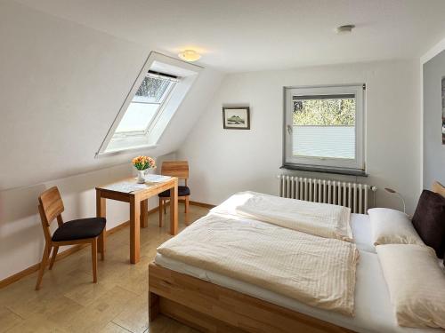una camera con letto, tavolo e finestra di Haus *Üüs Aran* Wohnung Nr. 2 a Wittdün