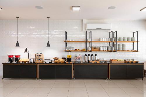 a kitchen with black counters and a white wall at Monreale Express Glicério Campinas in Campinas