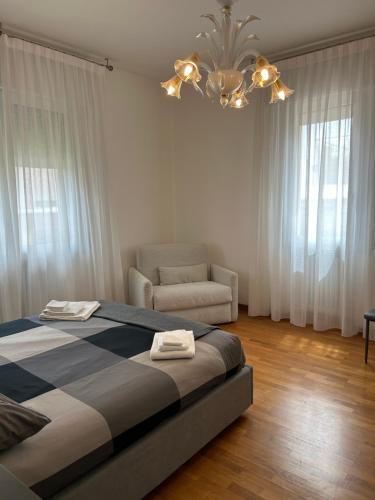 a bedroom with a bed and a chair and a chandelier at Doge Beato Apartment in Venice-Lido