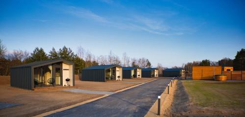 eine Reihe modularer Häuser auf einem Parkplatz in der Unterkunft SKAN-PARK Ferienhäuser & Tiny Houses am Bärwalder See 
