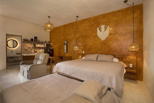 Wayuum Suites Cozumel Oasis in Paradise في كوزوميل: غرفة نوم بسرير وطاولة وكراسي