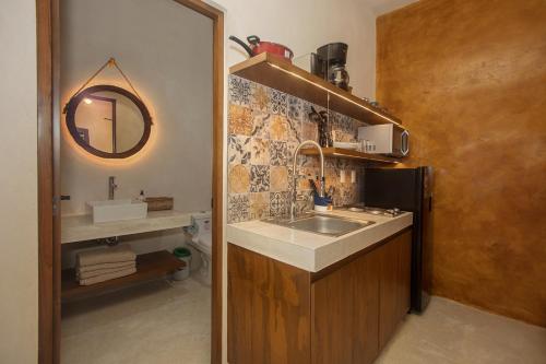 Wayuum Suites Cozumel Oasis in Paradise في كوزوميل: مطبخ صغير مع حوض ومرآة
