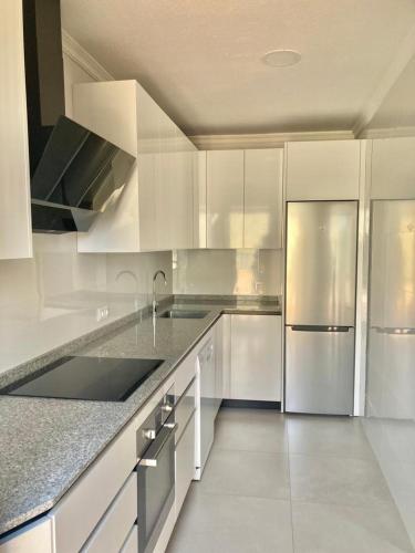a kitchen with white cabinets and stainless steel appliances at Apartamentos Azafranal-PARKING GRATIS- in Salamanca