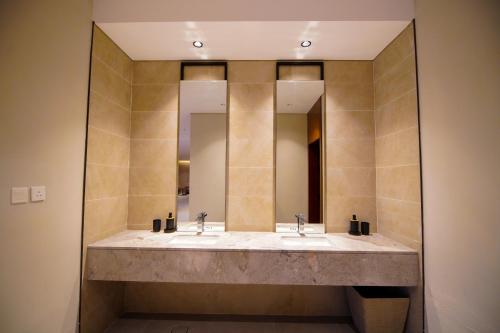 łazienka z 2 umywalkami i 2 lustrami w obiekcie La Terra Chalets 2 w mieście Dżudda