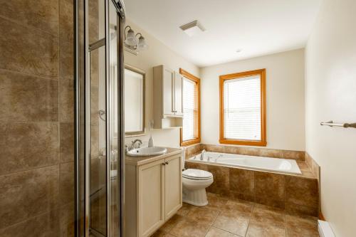 La salle de bains est pourvue d'une baignoire, de toilettes et d'un lavabo. dans l'établissement Serenity Peaks Lodge by InstantSuites-LaBete Golf, à Mont-Tremblant