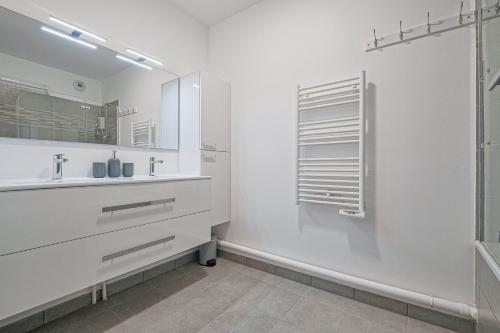 a white bathroom with a sink and a shower at Coco - Appartement F4 à 10 minutes de Disneyland Paris in Bailly-Romainvilliers
