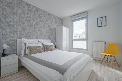 1 dormitorio con 1 cama grande y 1 silla amarilla en Coco - Appartement F4 à 10 minutes de Disneyland Paris, en Bailly-Romainvilliers