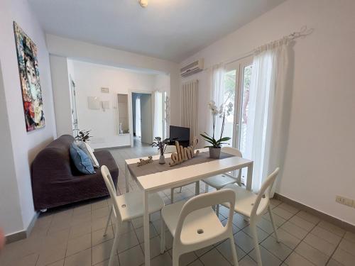 a living room with a table and chairs and a couch at Residenza Clelia Riccione in Riccione