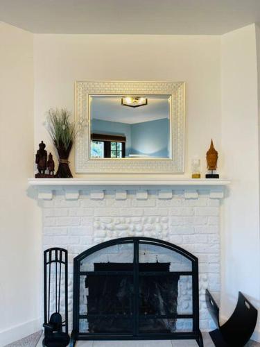 a living room with a fireplace with a mirror at Phinneywood Cottage - Greenlake - Zoo - Phinney in Seattle