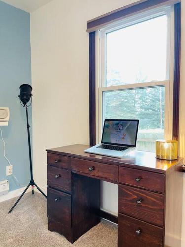 a desk with a laptop computer on top of it at Phinneywood Cottage - Greenlake - Zoo - Phinney in Seattle