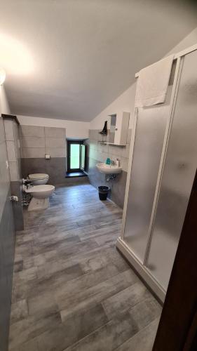 een badkamer met 2 toiletten, een wastafel en een douche bij B&B In Sabina in Poggio Nativo