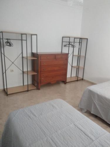 a bedroom with two beds and a dresser and two mirrors at El 20 in Barbate