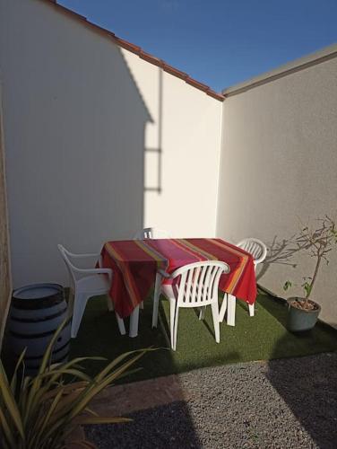 d'une terrasse avec une table, deux chaises, une table et des chaises. dans l'établissement Maison centre ville de Brétignolles sur Mer, à Bretignolles-sur-Mer
