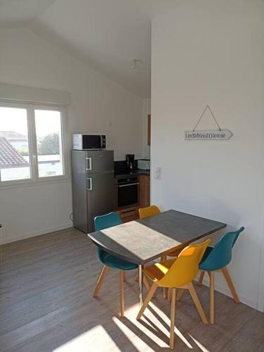 une cuisine avec une table et des chaises dans une pièce dans l'établissement Maison centre ville de Brétignolles sur Mer, à Bretignolles-sur-Mer