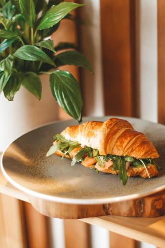 een broodje op een bord naast een potplant bij The Carmen Hotel - Ocean Front in Playa del Carmen