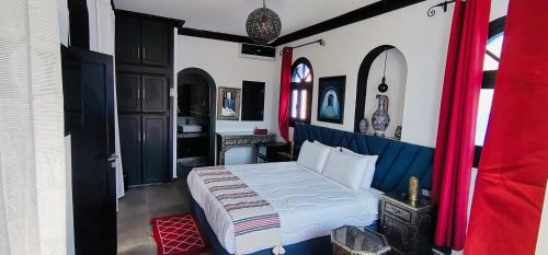 a bedroom with a bed and a red curtain at Riad El Palacio & Spa Chaouen in Chefchaouen