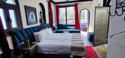 a bedroom with a bed and a chair in a train at Riad El Palacio & Spa Chaouen in Chefchaouene