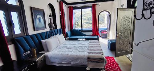 a bedroom with a bed and a chair in a train at Riad El Palacio & Spa Chaouen in Chefchaouen