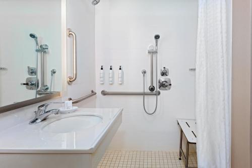 uma casa de banho branca com um lavatório e um chuveiro em SpringHill Suites Asheville em Asheville
