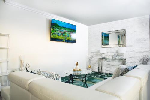 uma sala de estar com dois sofás brancos e uma lareira em La Vue de Basseterre Apartments - Luxury in Bird Rock em Basseterre