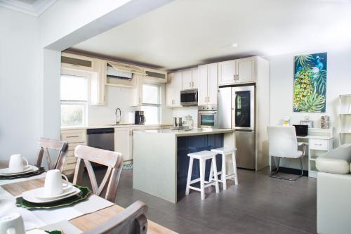 a kitchen with white cabinets and a table and chairs at La Vue de Basseterre Apartments - Luxury in Bird Rock in Basse Terre Town