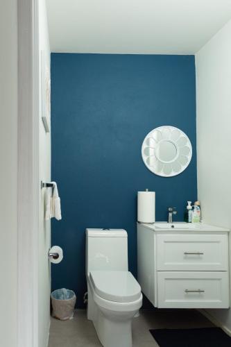 baño con aseo blanco y pared azul en La Vue de Basseterre Apartments - Luxury in Bird Rock, en Basseterre