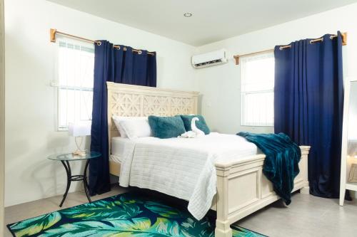 Un dormitorio con una cama con cortinas azules. en La Vue de Basseterre Apartments - Luxury in Bird Rock, en Basseterre