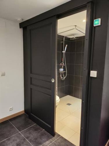 een badkamer met een zwarte deur en een toilet bij Flor'Ever en Champagne in Fleury-la-Rivière