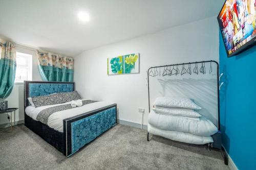 - une chambre avec un lit doté d'une tête de lit bleue dans l'établissement *2a* ground floor house setup for your most amazing & relaxed stay + Free Parking + Free Fast WiFi, à Beeston