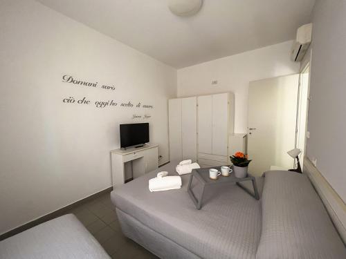 a room with a bed and a table with a tv at Residenza Clelia Riccione in Riccione