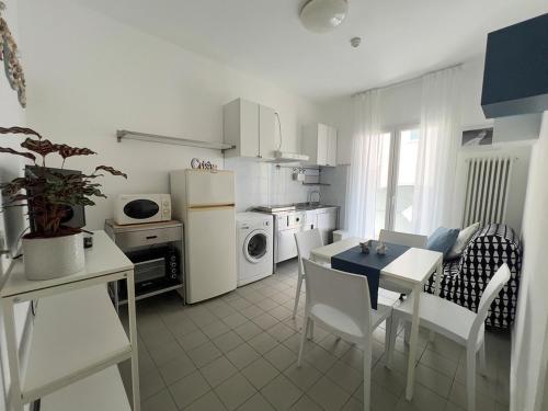 a white kitchen with a table and a dining room at Residenza Clelia Riccione in Riccione