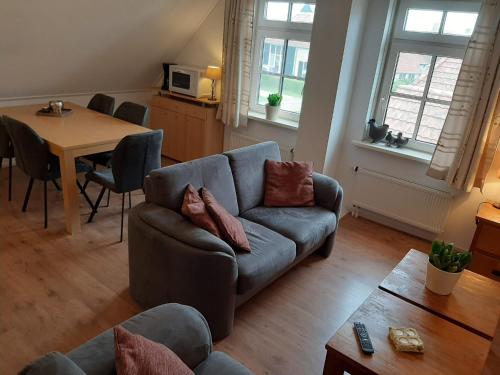 een woonkamer met een bank en een tafel bij Uut in Thuus in Buren