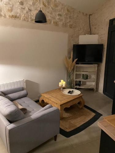a living room with a couch and a coffee table at Le studio d Inès in Vergèze