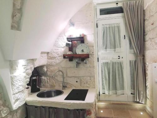 a small kitchen with a sink and a window at Archetto Bianco in Martina Franca