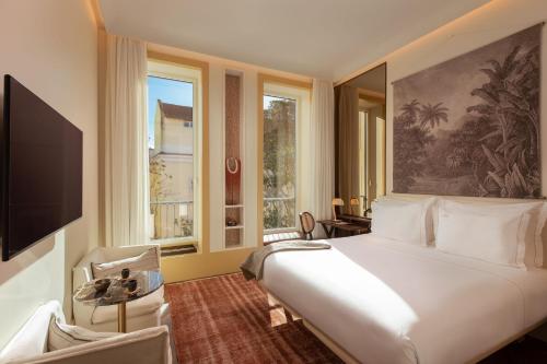 a bedroom with a large white bed and a window at The Ivens Autograph Collection in Lisbon