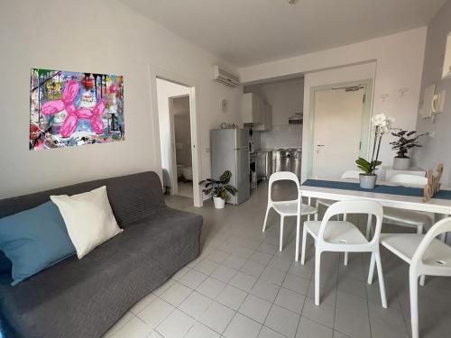 a living room with a couch and a table and chairs at Residenza Clelia Riccione in Riccione